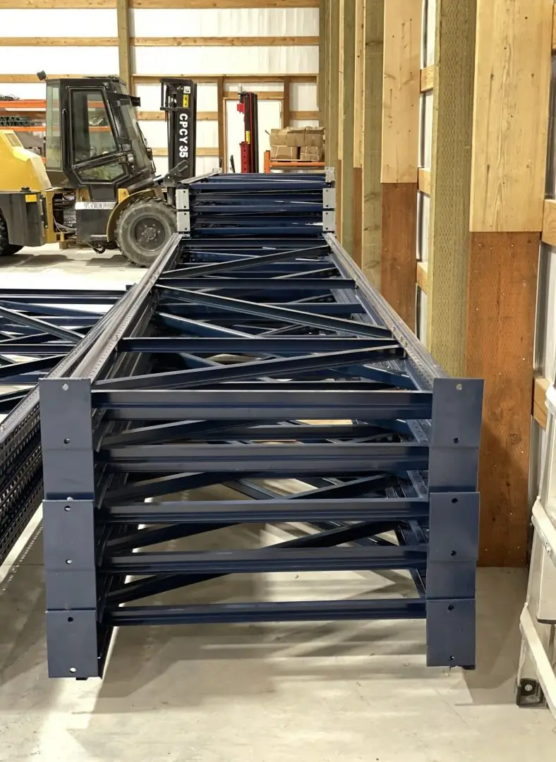 Stack of new teardrop pallet rack uprights